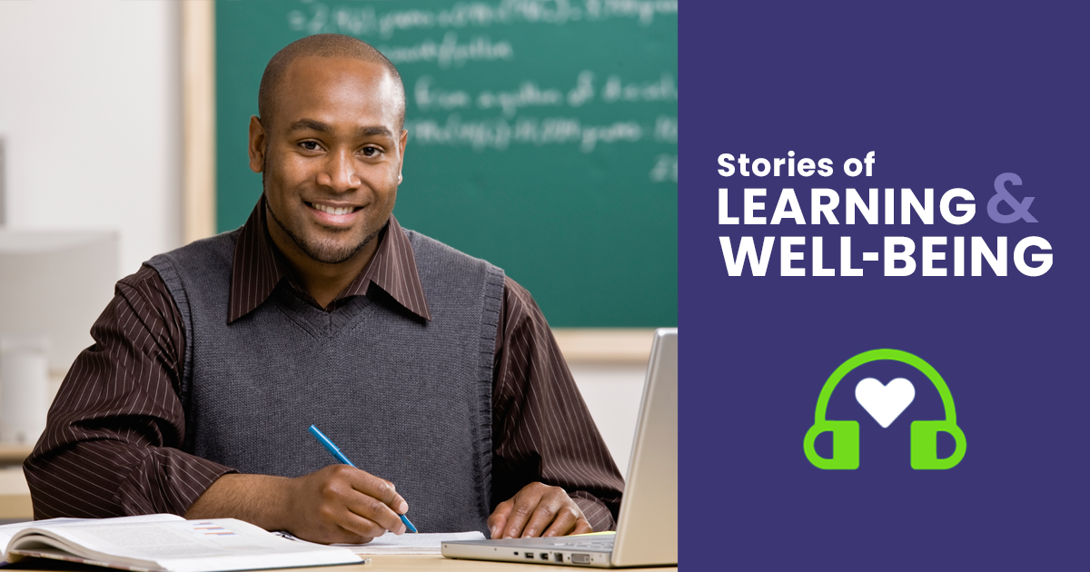 A teacher working on a computer in a classroom.