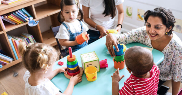 Children at a table learning with teacher