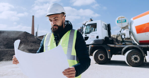 Construction worker reviews construction plans onsite.