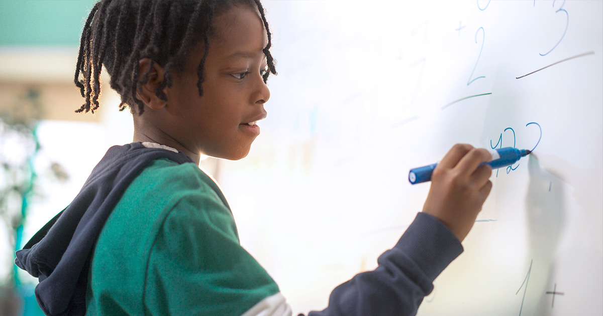 Student writing on whiteboard
