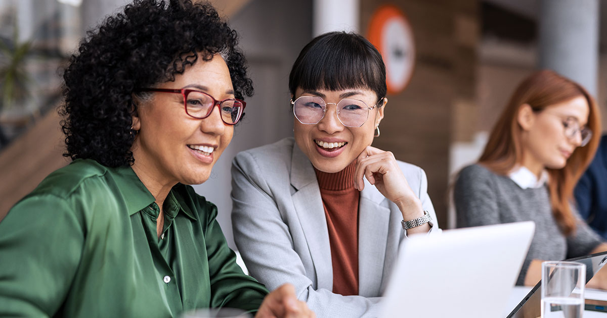 Two women in discussion, looking at a laptop